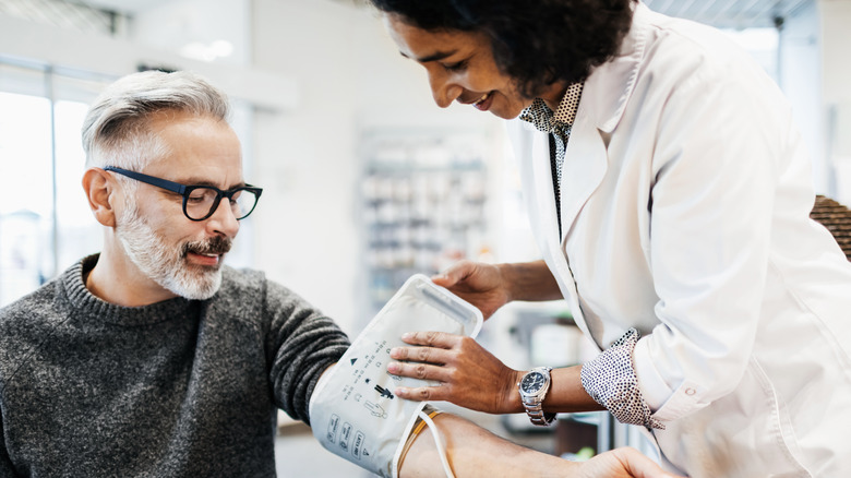 older man having blood pressure taken