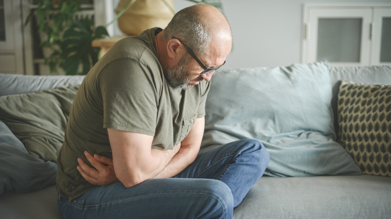 Man holding stomach in pain