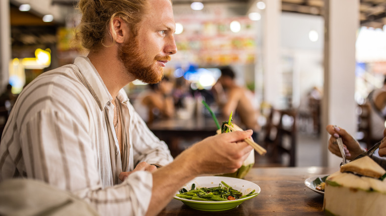 man eating a plate of asparagus