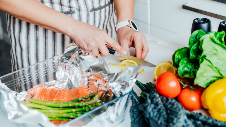 close up of women preparing meal with asparagus