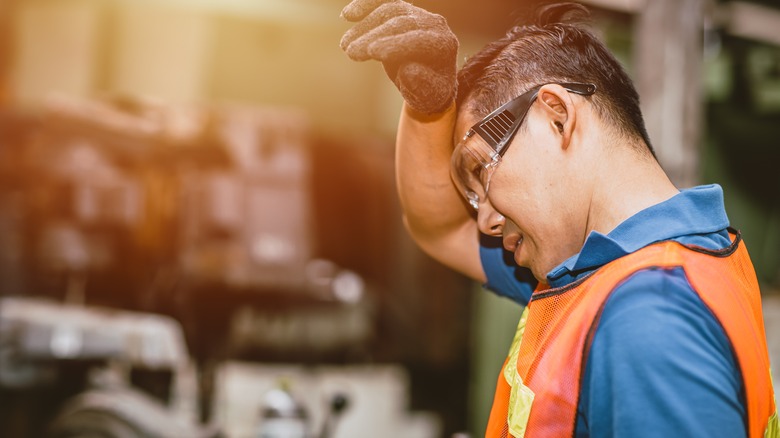 Worker wiping forehead