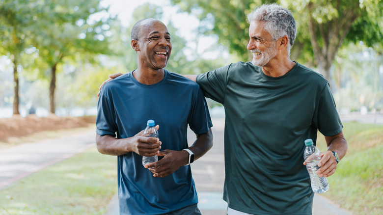 Two smiling men walking outside