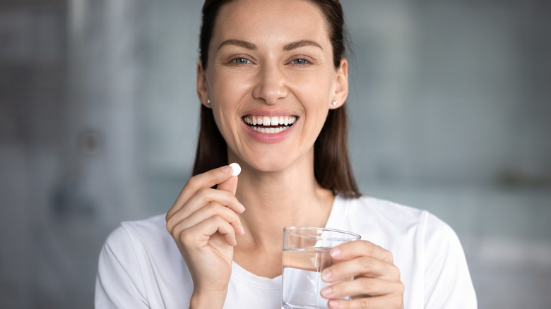 A woman takes a probiotic supplement