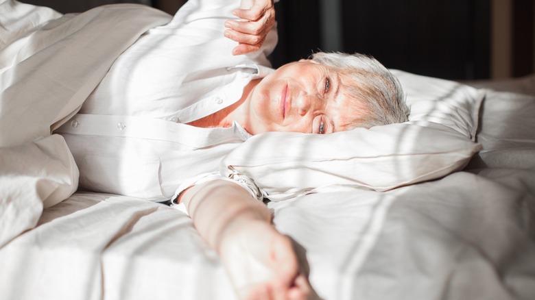 Older woman waking up in bed