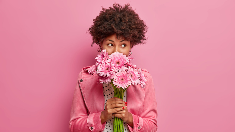 Black woman smelling flowers