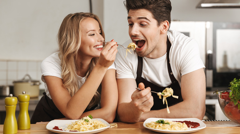 Man and woman eating spaghetti