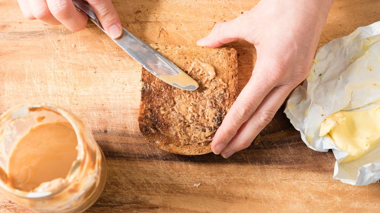 Woman making peanut butter toast