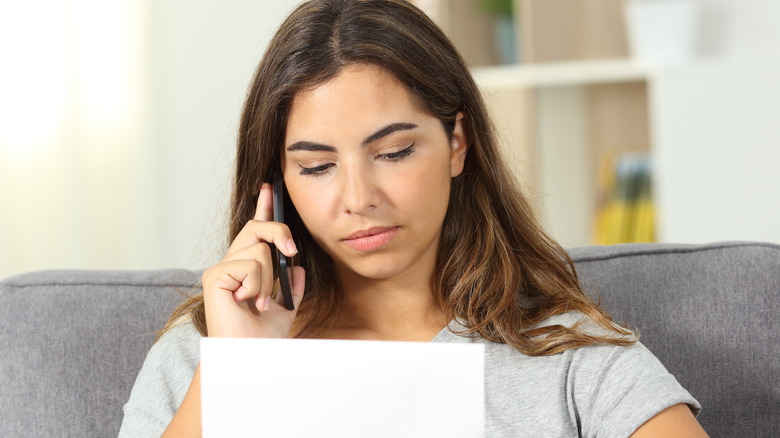 Woman on phone holding paper