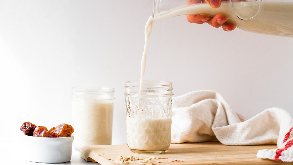 pouring oat milk into glass