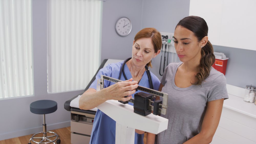 doctor weighing a patient