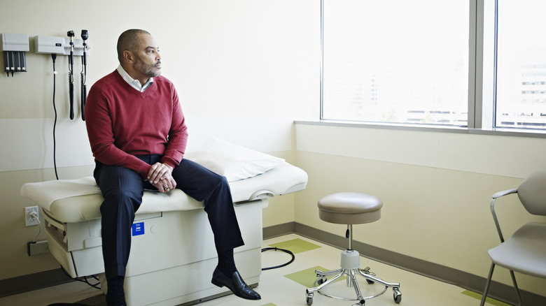 An older man waiting nervously in a doctor's office