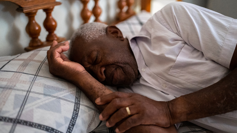 Older man asleep on bed