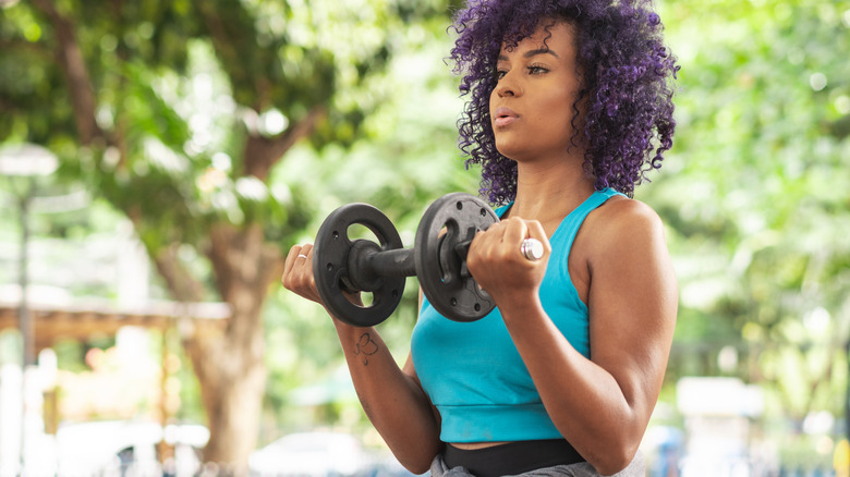 young woman holding free weight with both hands