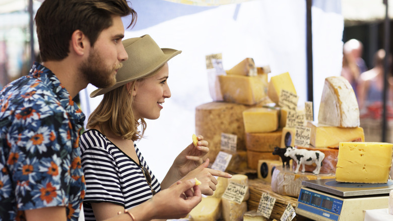 person slicing yellow cheese