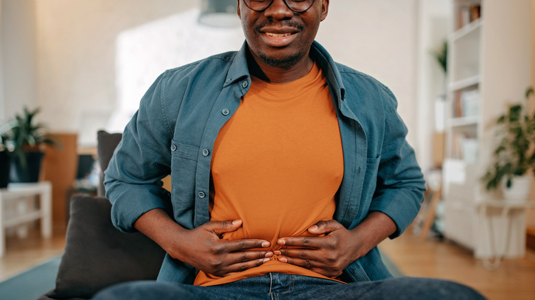 Man in discomfort holding stomach