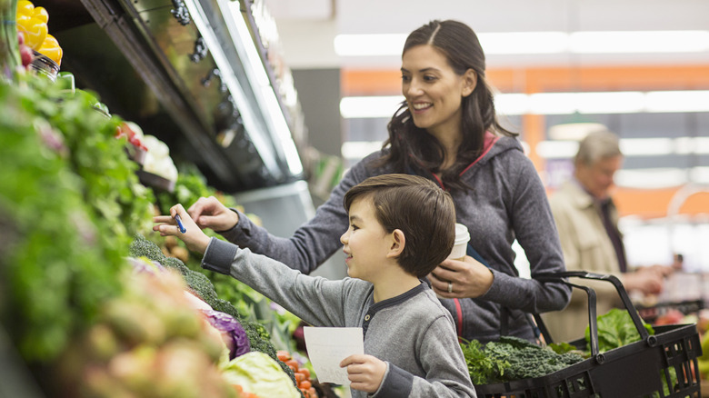 woman shopping for vegetables with son