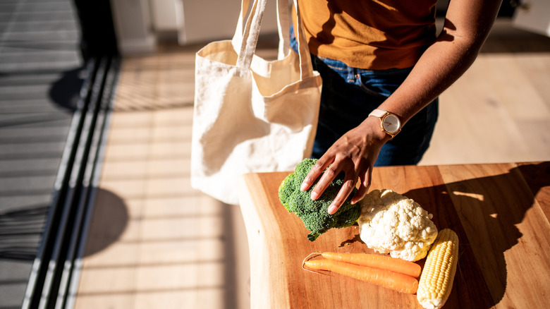 person putting veggies on the counter