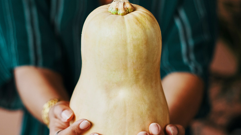 woman holding a butternut squash