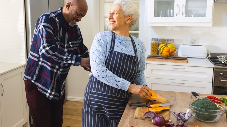 A couple cooking with butternut squash