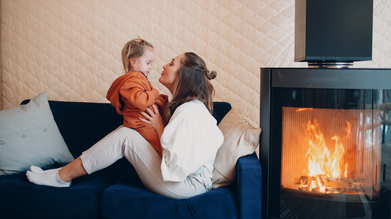 Woman and child by fireplace