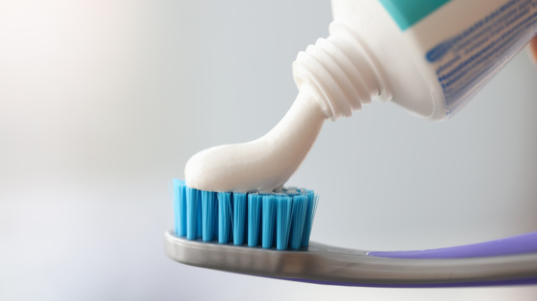 Toothpaste being squeezed on toothbrush