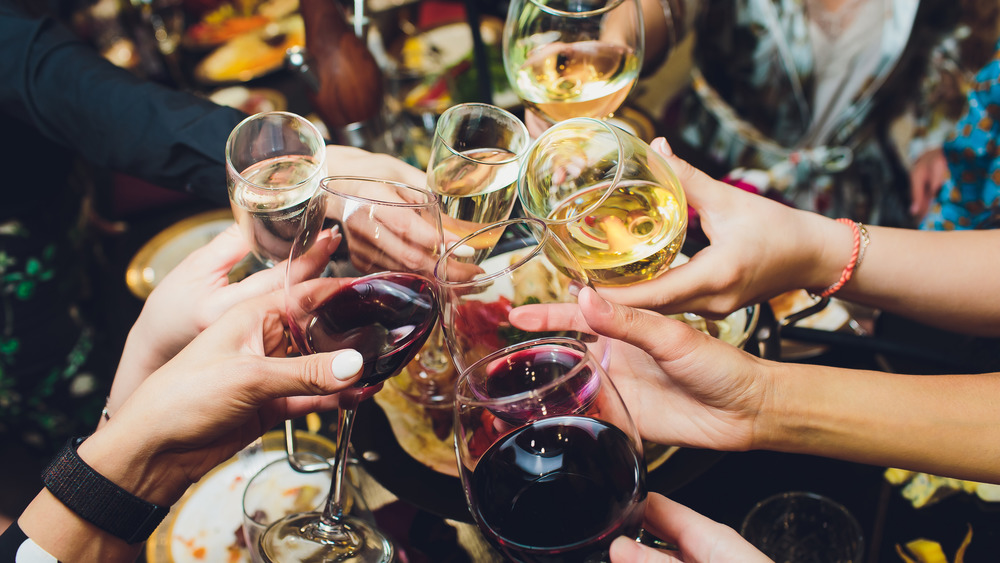 People clinking a bunch of wine glasses