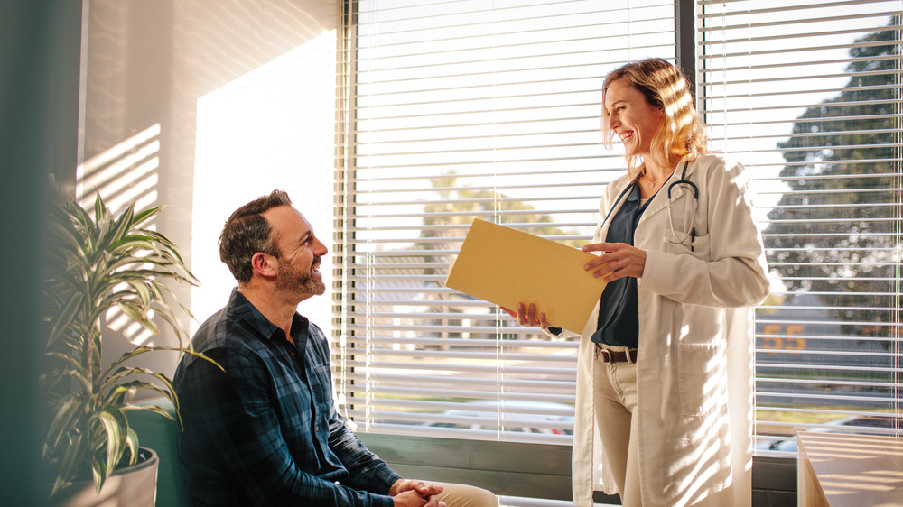 Doctor smiling at her patient next to an open window