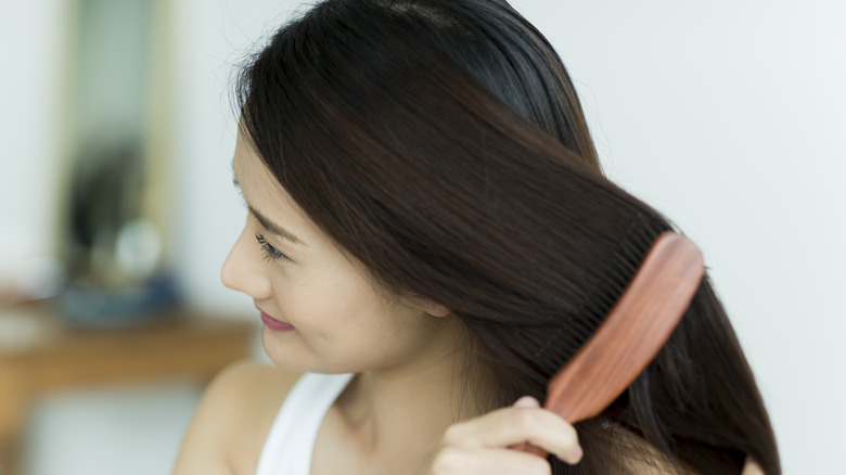 Young woman brushing hair
