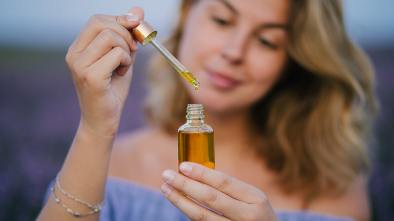 A woman holds a bottle of lavender oil