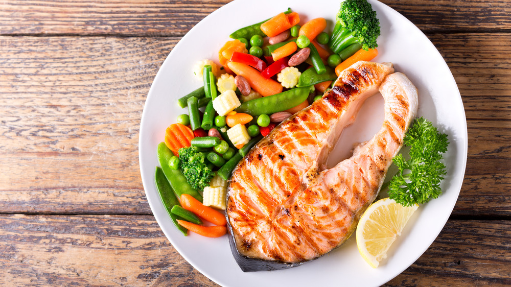 Grilled fish on a plate with vegetables