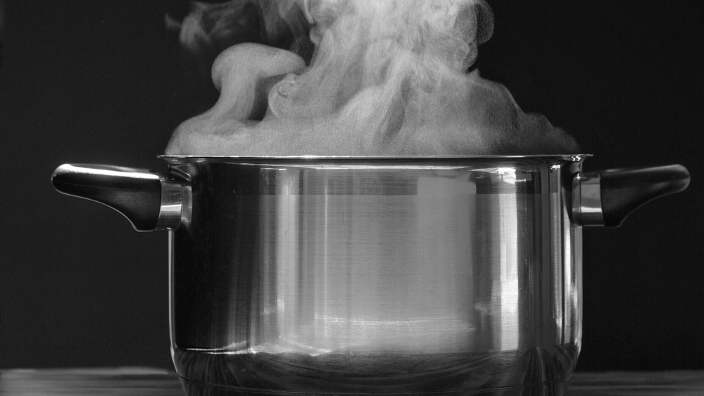 Steaming pot on black background