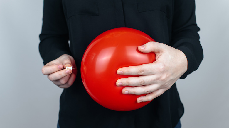 person holding balloon to symbolize bloating