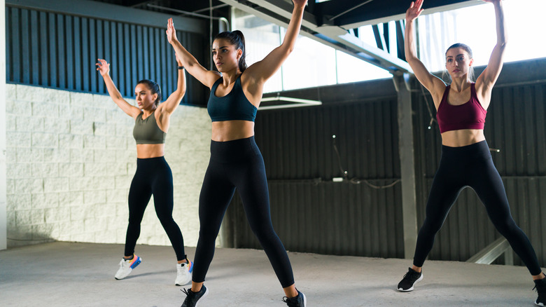 Three women take part in a HIIT class