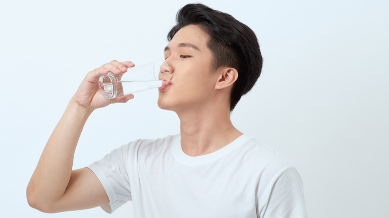 man drinking a glass of water