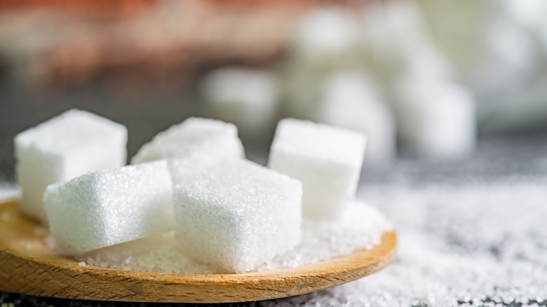 Cubes of sugar on wooden plate