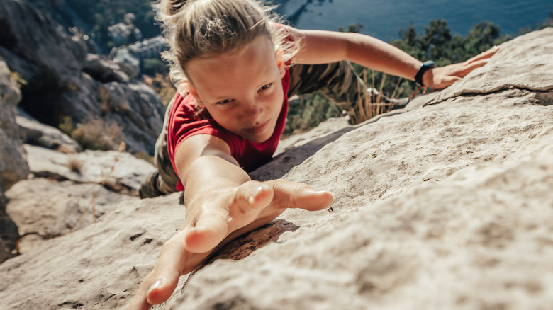 Woman climbing rock face