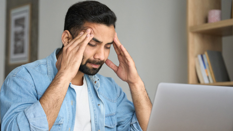 Man with headache holding head