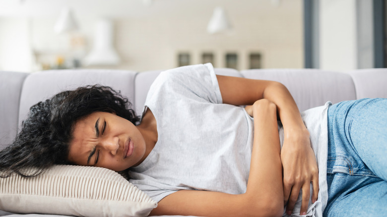 Woman lying down holding stomach