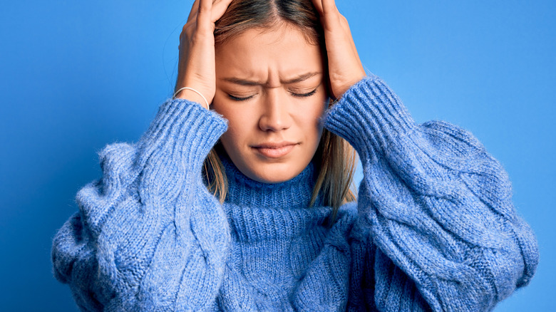 Woman holding head in frustration