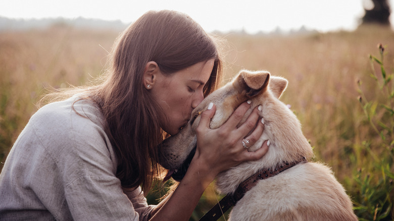 woman kissing dogs head