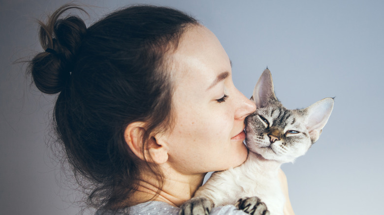 woman snuggling pet cat