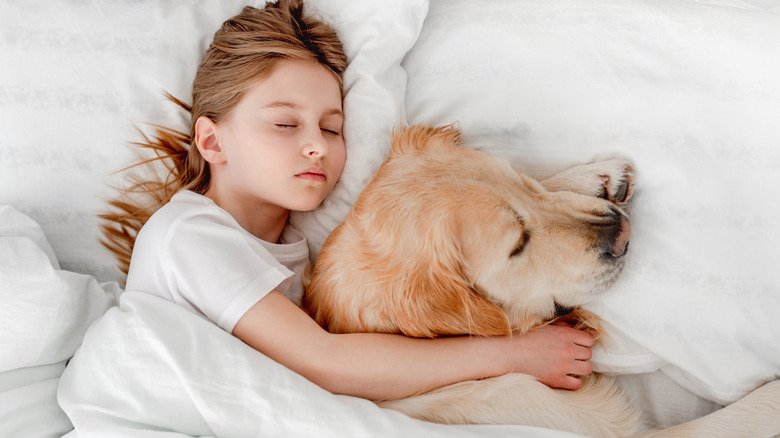 little girl sleeping with dog