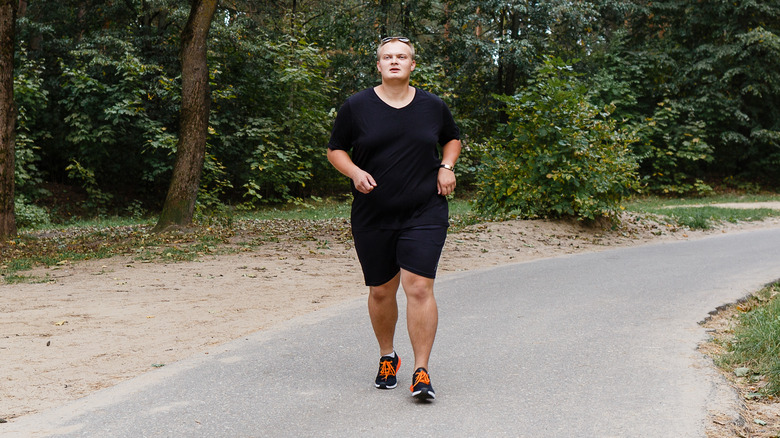overweight man running through park