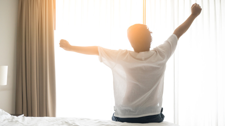 man stretching by window