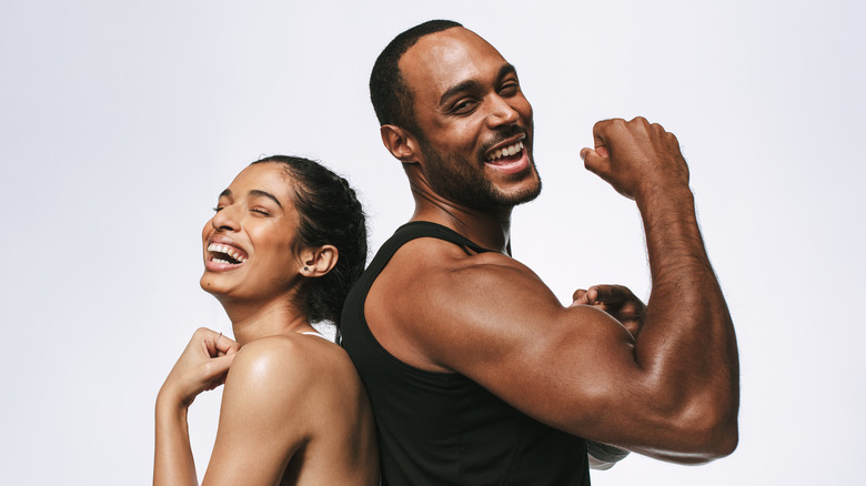 Man and woman flexing muscles