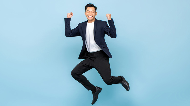 Joyful man jumping with blue background