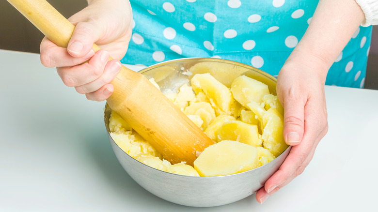 Woman mashing potatoes in a bowl