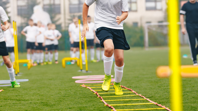 A young soccer player using an agility ladder