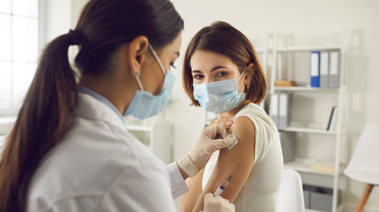 Woman in face mask getting Covid-19 vaccine