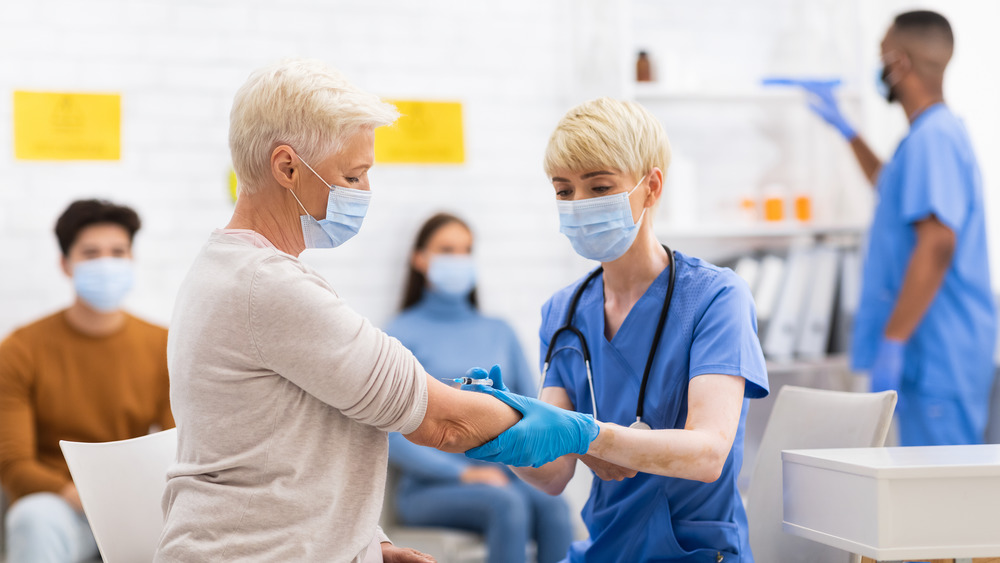 Stock photo of senior woman receiving a vaccine